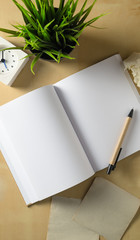 open blank notebook with a brown pen on wooden table