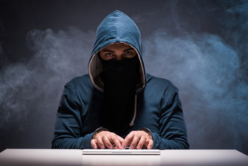 Computer hacker working in dark room