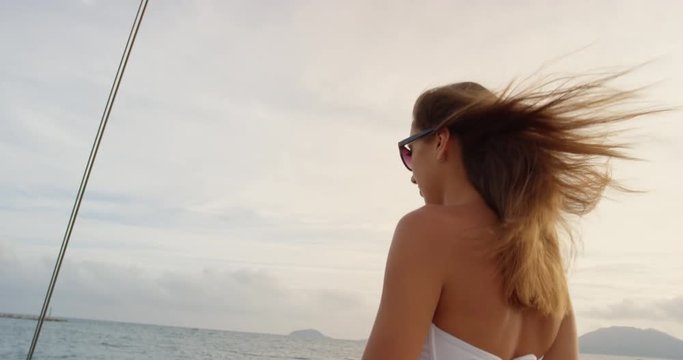 Beautiful woman on sailboat in bikini in ocean on luxury summer lifestyle happy adventure travel vacation