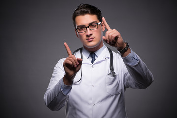 Young doctor against dark background