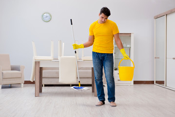 Man cleaning the house helping his wife