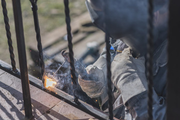 A worker welding metal handrails on the stairs. Ukraine.