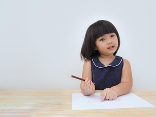 Happy asian kid girl drawing with colored pencil, Child learning and playing at home