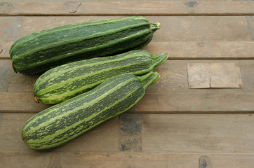 Close up of  three garden zucchini on a vintage wooden trunk.