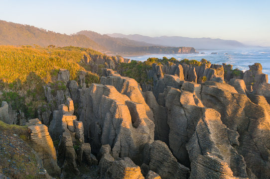 Sunlit cliffs, rocks and ocean coastline landscape