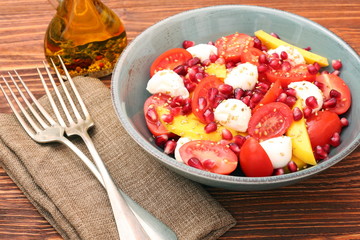 Tomato salad, mango and mozzarella with pomegranate seeds