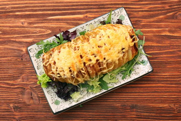 Sliced baked potatoes with cheese and bacon