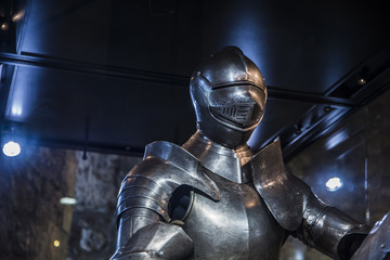 Man in a medieval armor with castle walls in background