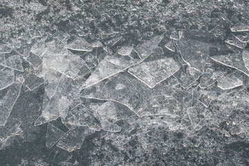 Abstract background of shards of broken ice glittering in the sun on the ice on a frozen lake