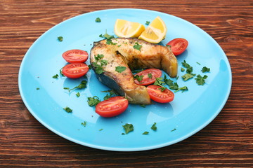 Steak of sturgeon with lemon and tomatoes