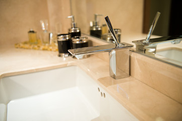 Closeup of sink and faucet in modern bathroom.
