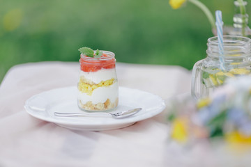 Erdbeer Creme Dessert im Glas geschichtet auf Picknicktisch