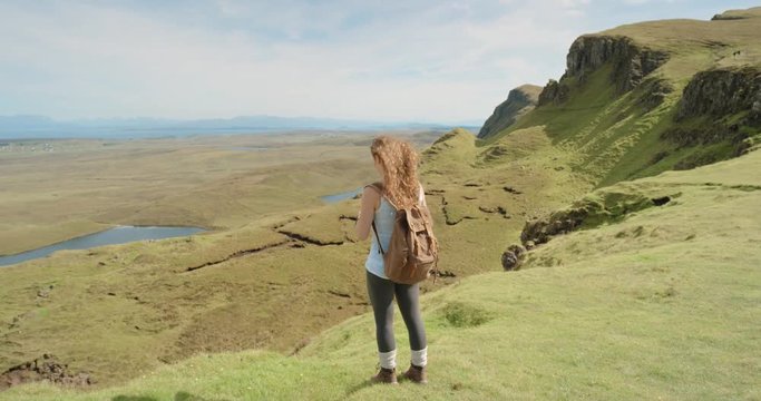Hiker Woman taking photograph smartphone photographing scenic landscape nature background view enjoying vacation travel adventure. Quiraing Walk on the Isle of Skye in Scotland