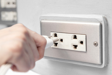 Connecting electric plug into socket.