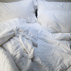 close up of messy bedding sheets and pillow
