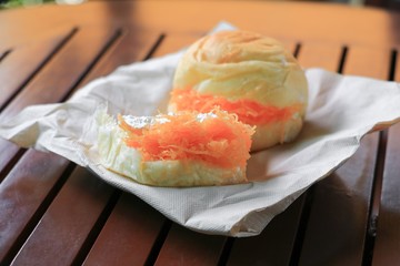 bread stuffed in paper napkin on a wooden table