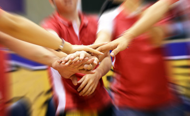team of friends showing unity with their hands together
