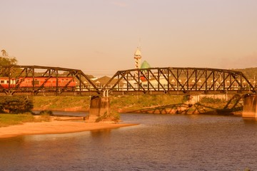 train on a bridge over river   with vintage sunset color tone and copy space add text