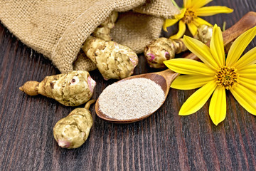 Fototapeta premium Flour of Jerusalem artichoke in spoon with flower on board