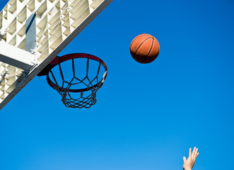 A basketball field goal with the sky in background.