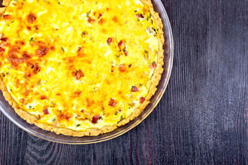 Quiche with pumpkin and bacon in pan on board top