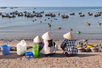 Three women in conical hats in Fishing village. Mui Ne. Vietnam