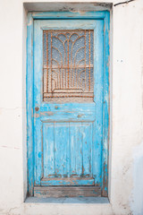 Fototapeta na wymiar Old shabby greek door, weathered by the wind.