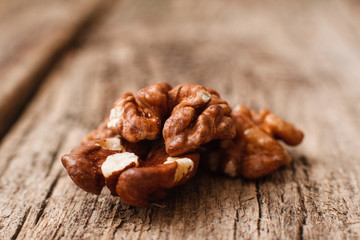 Walnut kernel on wooden background close up. Macro picture of nut on wood. Organic, vitamin, season, autumn concept