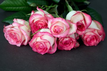 Bouquet of pink and white roses on stone table, closeup view