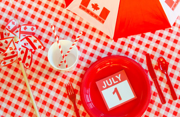 Red and white picnic items, a July 1 calendar page  with a pinwheel and umbrella for Canada Day.