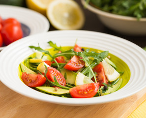Healthy food. Fresh salad of arugula with cherry tomatoes and avocado