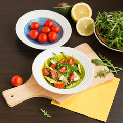 Healthy food. Fresh salad of arugula with cherry tomatoes and avocado