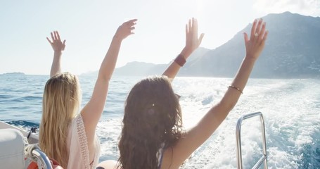 Woman dancing on boat at sunset Girl friends doing silly freestyle dance with arms in air on yacht enjoying sunset on party boat European summer holiday travel vacation adventure in Amalfi Coast Italy