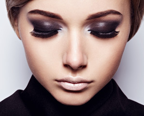 The girl's face closeup with long black lashes. fashion makeup
