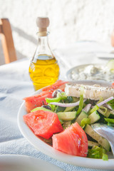 Fresh greek feta salad with oil and tzatziki in the background
