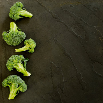 Brocolli florettes on a black slate background