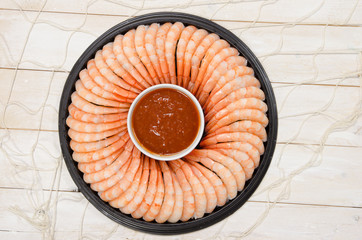 A Shrimp ring with seafood sauce on a rustic wood background