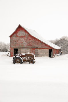 Vintage tractors in front of an old red barn at Christmas