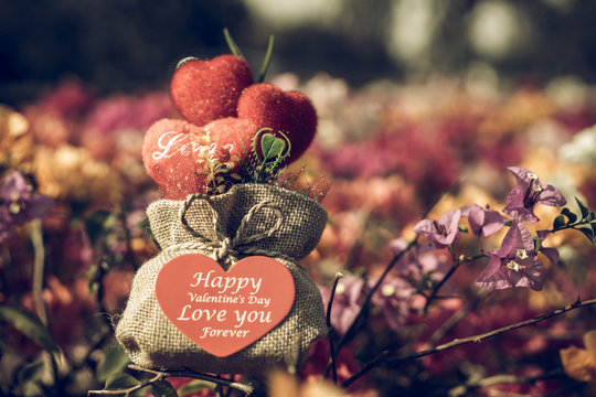 Valentine's Day gifts in a sack on a heart-shaped flowers.