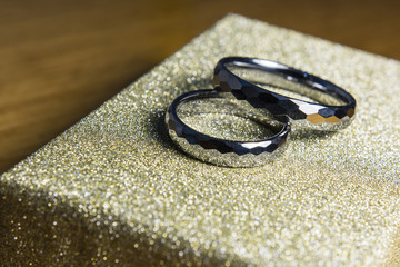 Two wedding rings made of tungsten on the cover box.