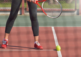 Young woman with racket ready to serve a tennis ball