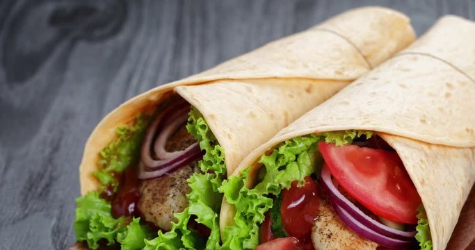 pan of chicken wrap sandwiches on wood board, 4k prores footage