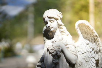 Statue of an angel with wings in the sunshine.