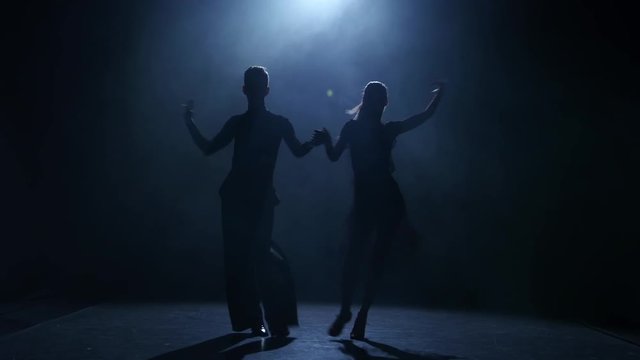 Dance element from the samba, silhouette couple ballroom. Black background