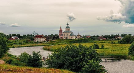 Fototapeta na wymiar View of Suzdal from the Kamenka river in overcast cloudy weather