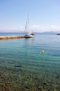 yacht moored in harbour with sea and mountain	