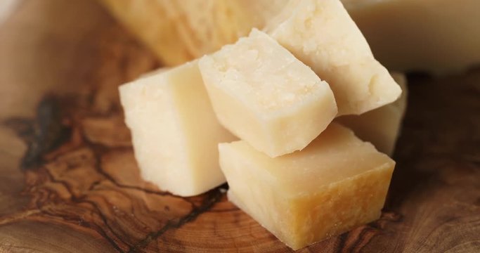 closeup pan of pieces of italian parmesan cheese on wood table, 4k prores footage