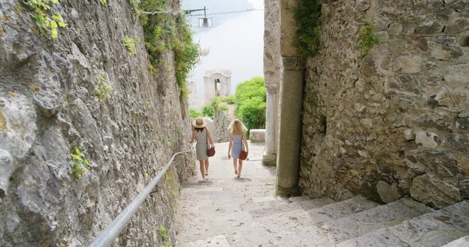 Tourist women exploring old town Girl walking through Italian street Best friends travelling enjoying summer vacation travel adventure in Ravello Amalfi Italy