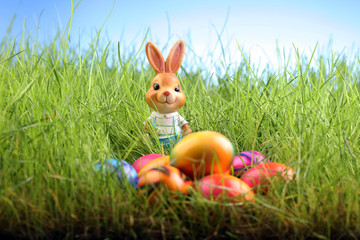Sugar rabbit and easter eggs on meadow.