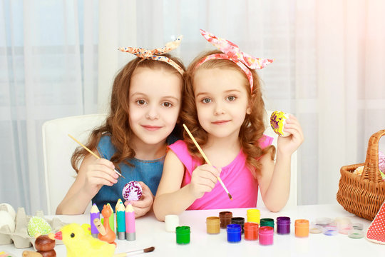 Two girls painting Easter eggs